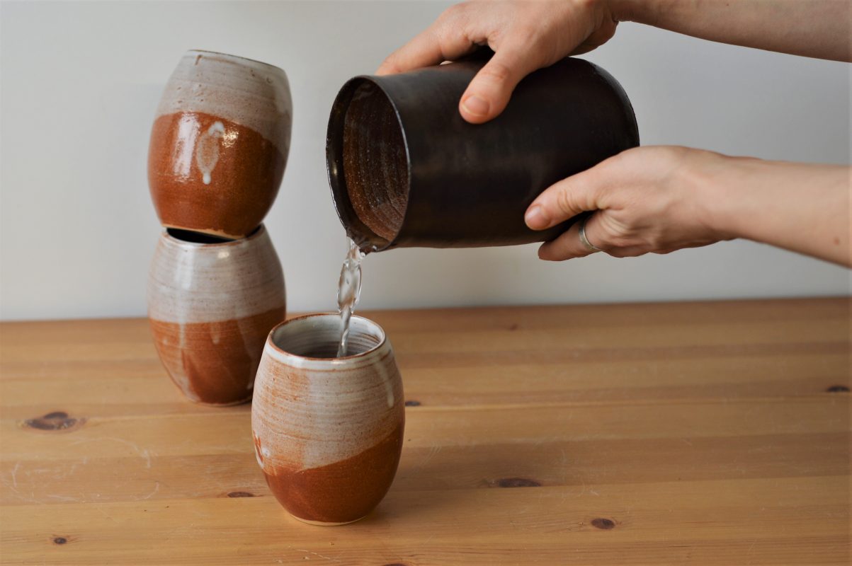 tasse sable - pichet d'alchimie - main et eau qui coule